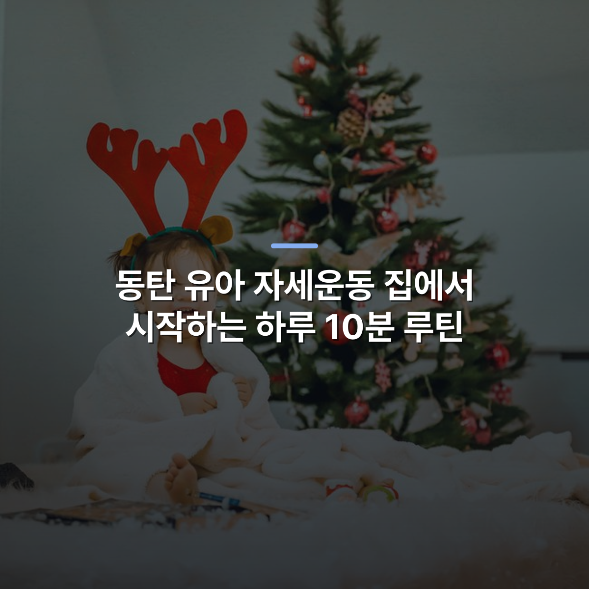 동탄 유아 자세운동 집에서 시작하는 하루 10분 루틴 · 사진: Adorable toddler in reindeer antlers sitting by a festive Christmas tree, bringing holiday cheer.